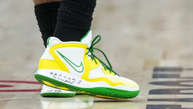 View of white, yellow, and green Kyrie Infinity shoes.